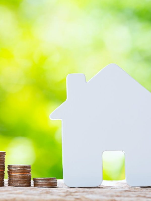world-habitat-day-close-up-picture-of-a-pile-of-coins-and-a-model-house-min